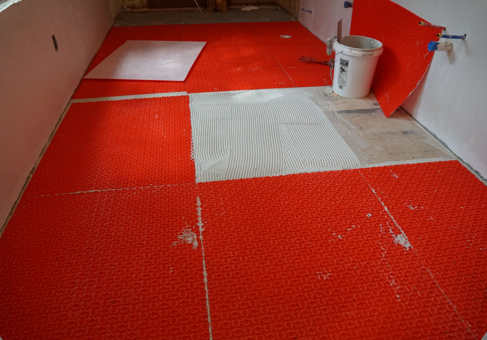 Uncoupling membrane being installed in a tiny house.