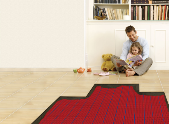 A dad and daughter sit on the heated floor, reading a book together.